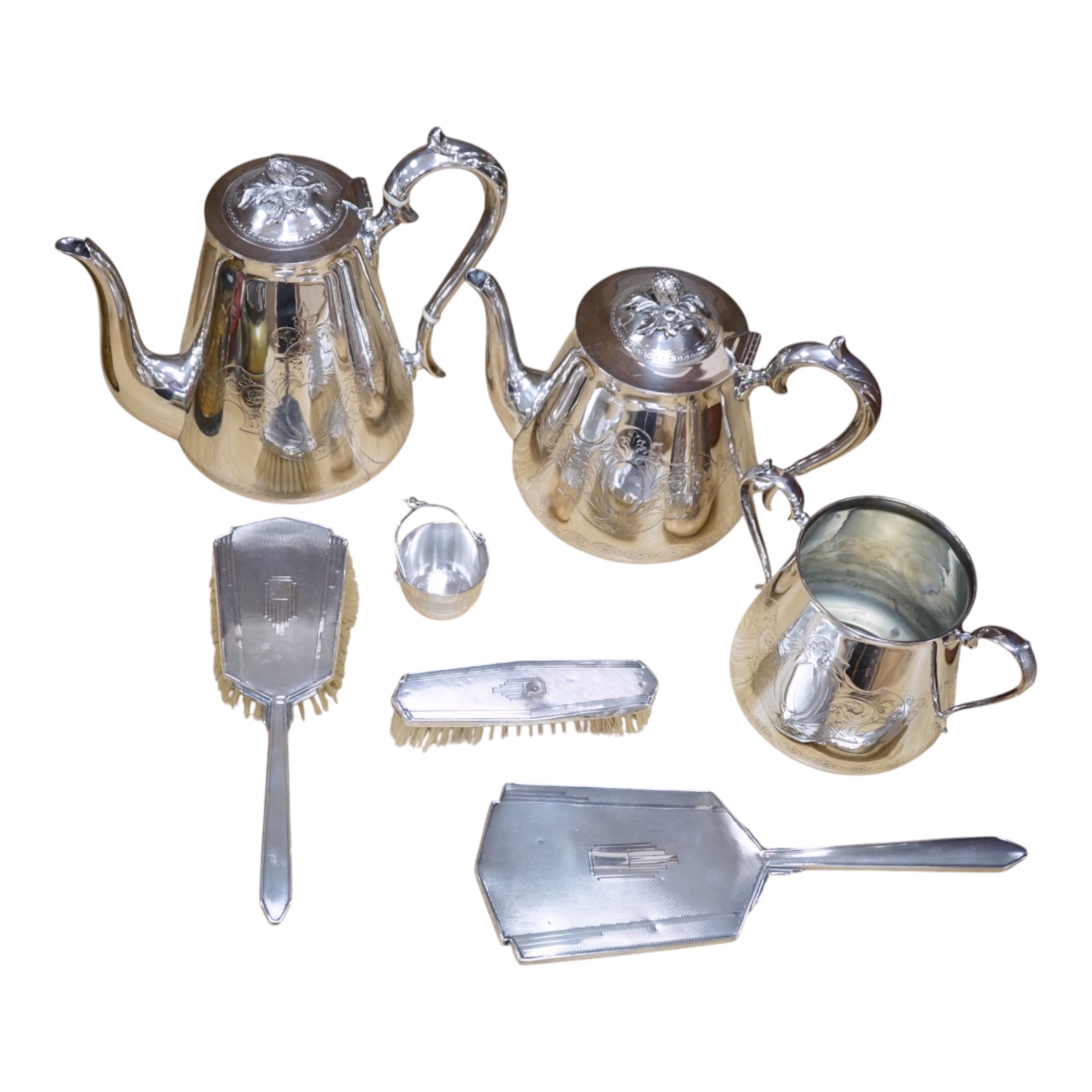 An Art Deco three piece silver brush set and a silver plated three piece tea set and miniature caldron, coffee pot 22cm high. Condition - fair